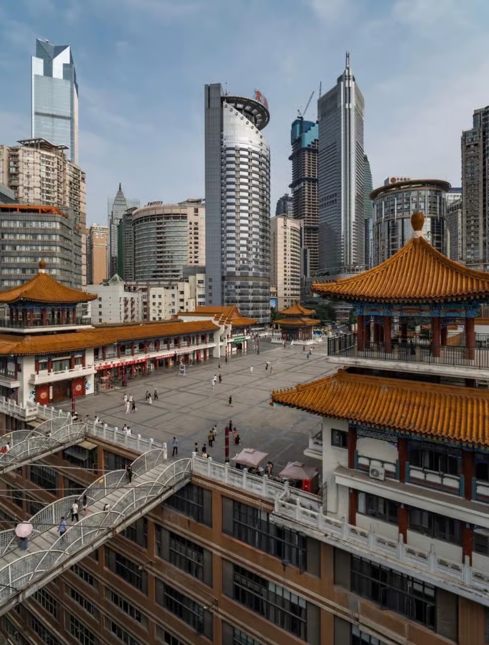 Traditional rooftops and layered walkways framed by Chongqing's modern downtown skyline