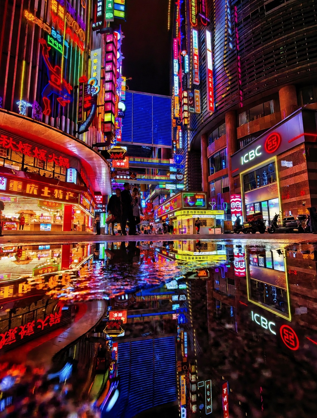 Neon signs reflected in a rain-wet downtown Chongqing street