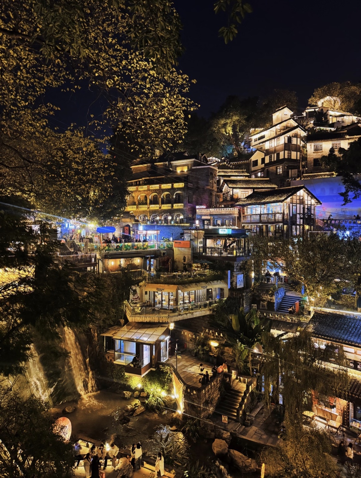 A glowing hillside neighborhood after dark on the full-day route